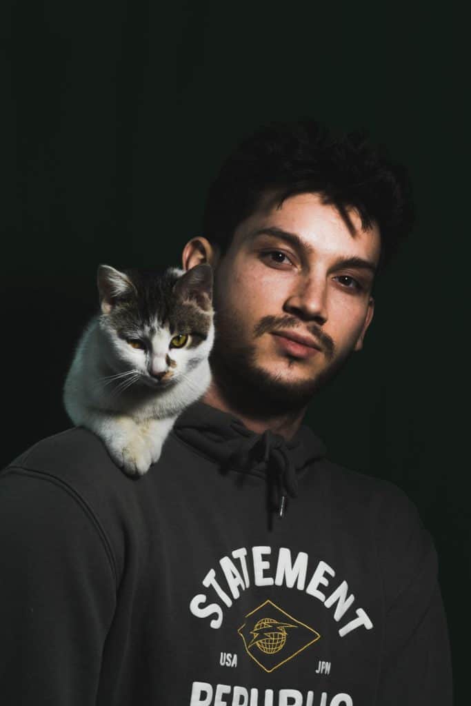 man holding a cat on shoulder
