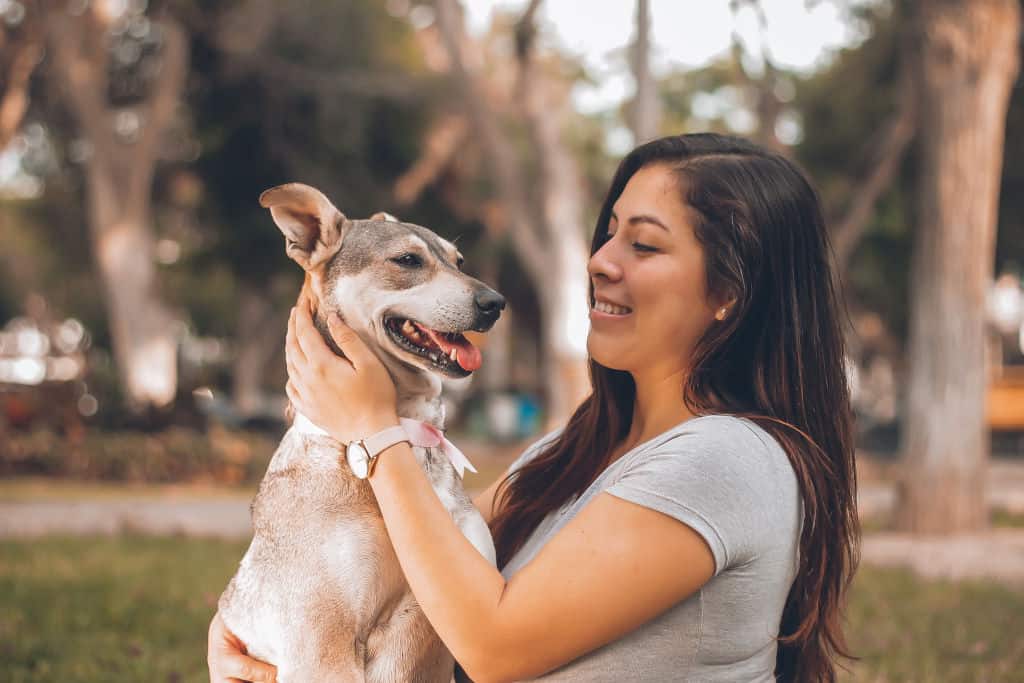 woman holding a dog in the park