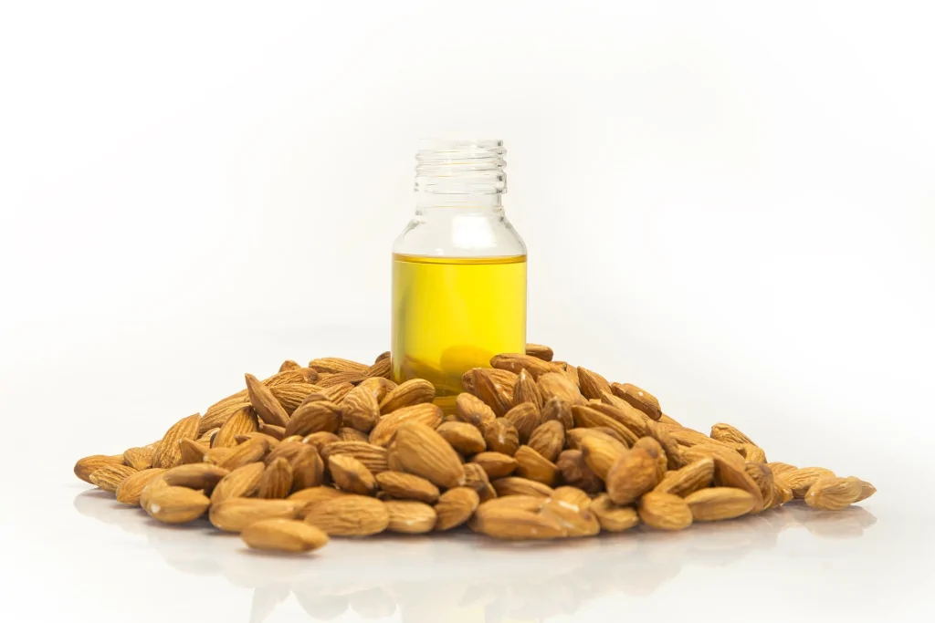 bottle of almond oil in the middle of a pile of almonds