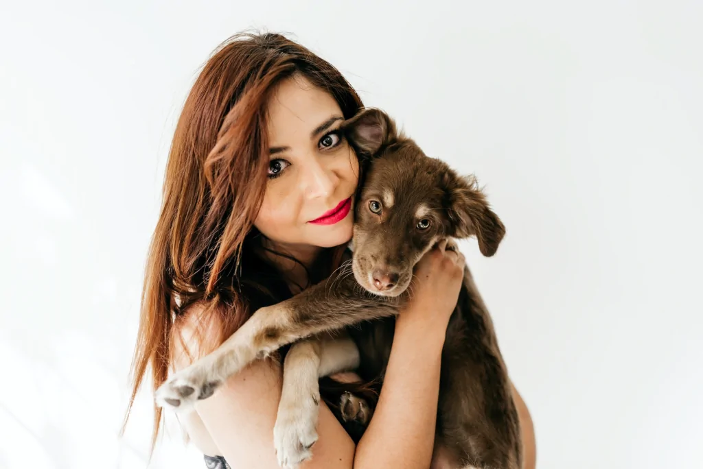 woman hugging a brown dog